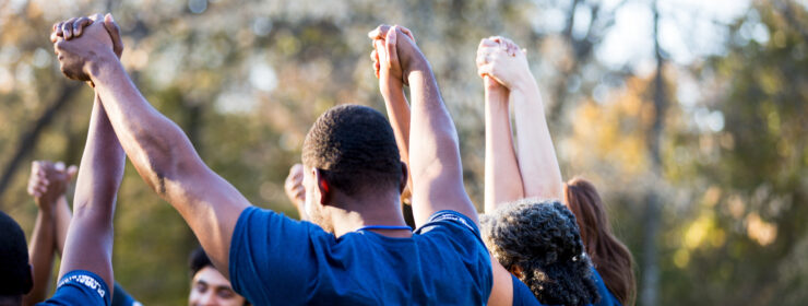 Neighbors hold hands in unity during cleanup event