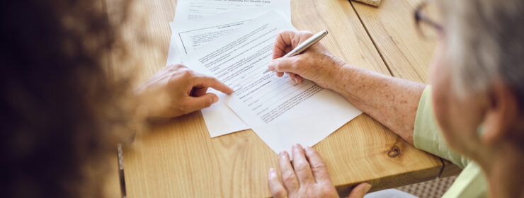 Senior Woman Signing Documents in Her Home