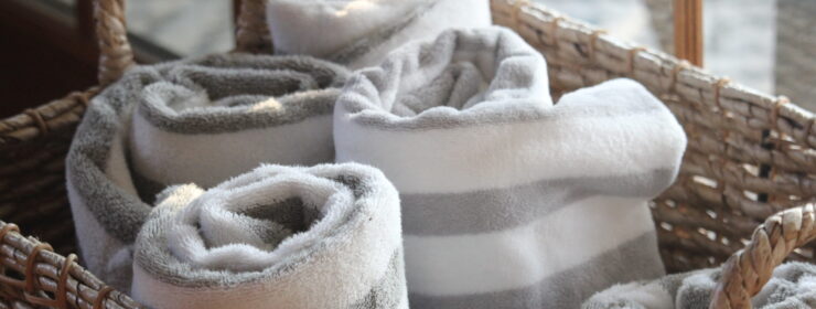 Striped Fluffy Towels Stored and Rolled up in a Basket at a Beach House