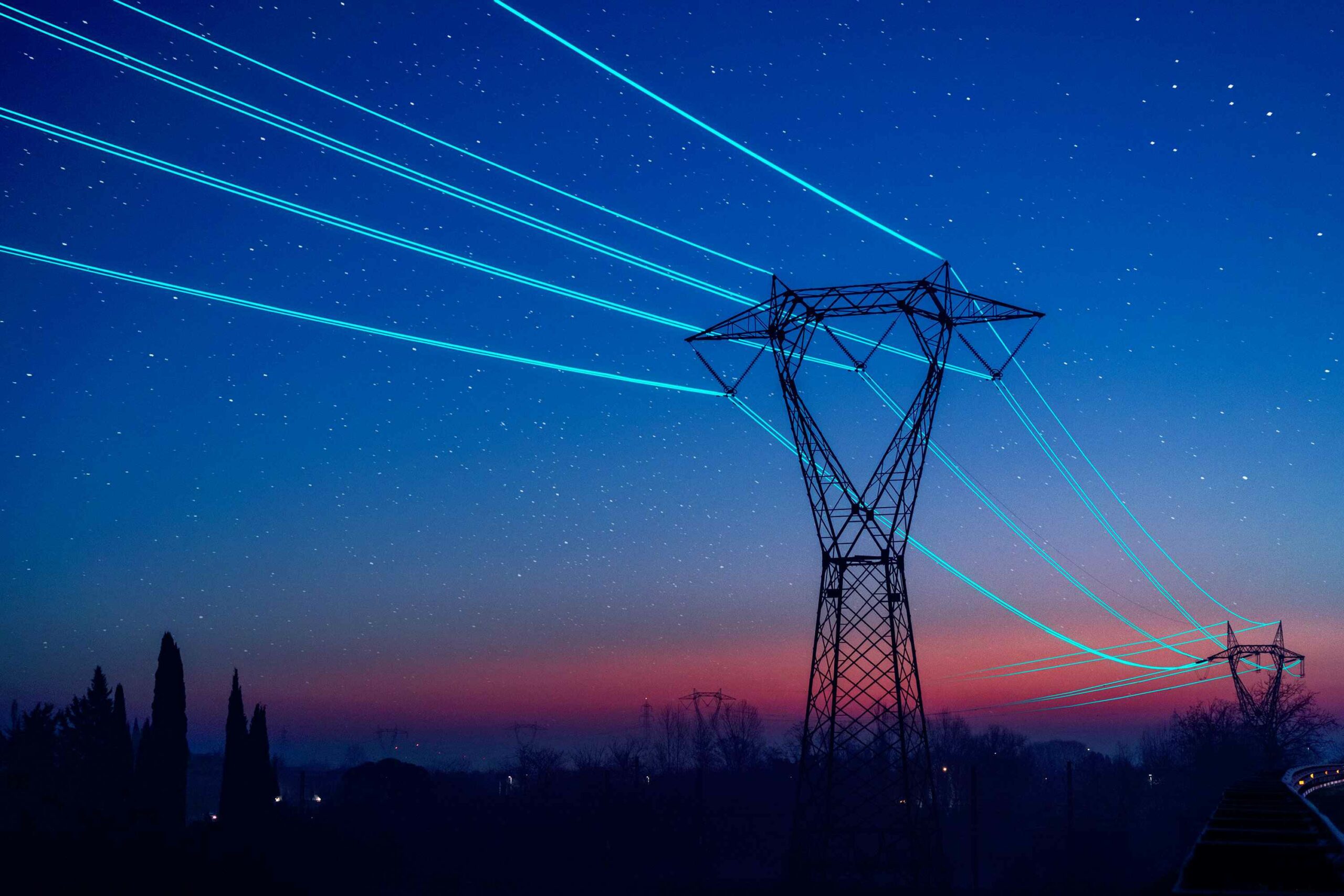 Electricity pilon with glowing cables over sunset sky