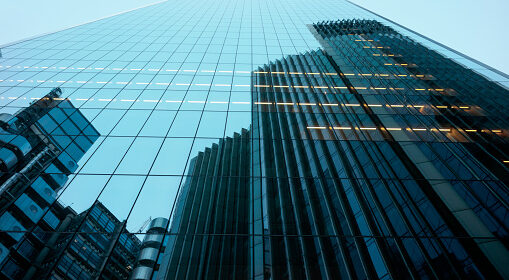 UK, abstract of glass and steel built office towers in London financial district against clear sky