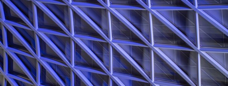 Kings Cross and St Pancras concourse ceiling at night with columns and patterns illuminated in purple light