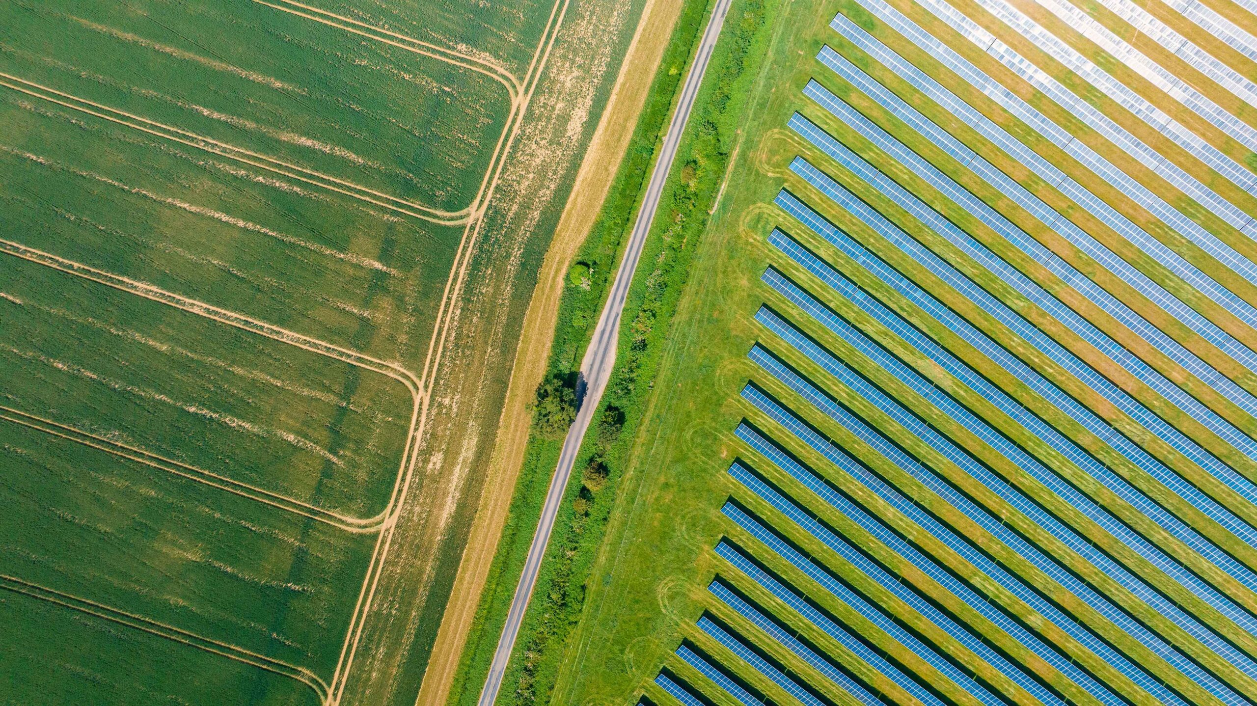 An aerial/drone view of a solar farm and agricultural fields in rural England