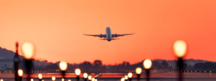 Airplane taking off at sunrise