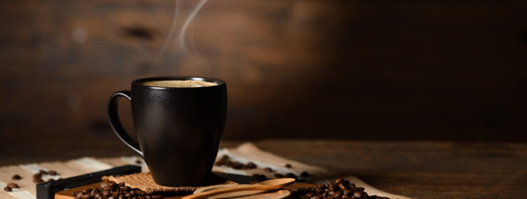 Cup of coffee with smoke and coffee beans on old wooden background|Birketts advises on sale of Paddy & Scott’s Cafes Ltd