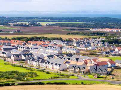 New homes in a building development surrounded by agricultural fields in East Lothian