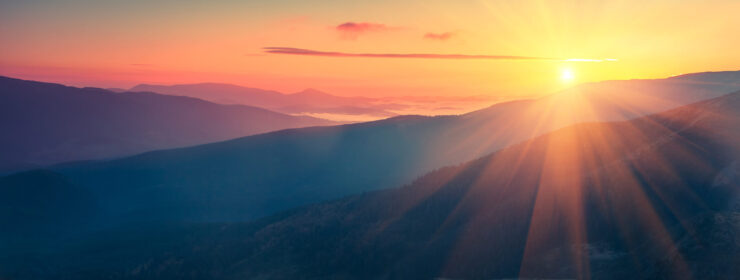 Panoramic view of colorful sunrise in mountains.