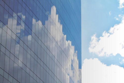 Reflection of clouds and sky on modern glass building