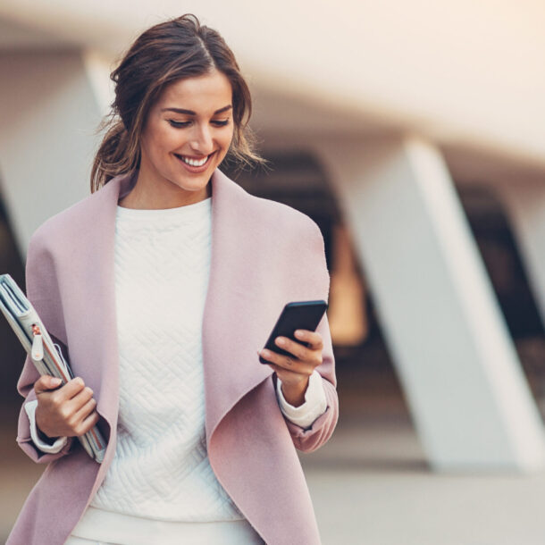 Smiling colleague reading mobile phone