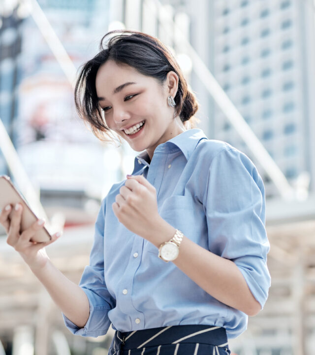 Smiling Colleague reading news on her phone